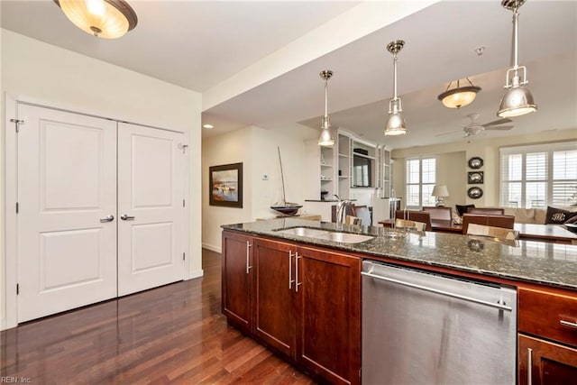 kitchen with dark stone counters, dishwasher, dark wood-style floors, open floor plan, and a sink