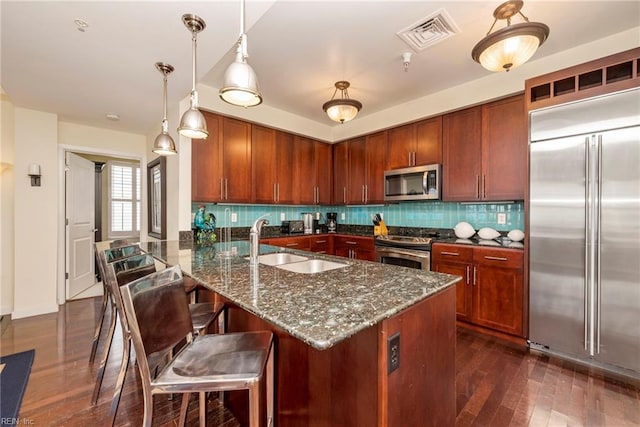 kitchen featuring stainless steel appliances, visible vents, a sink, and decorative backsplash