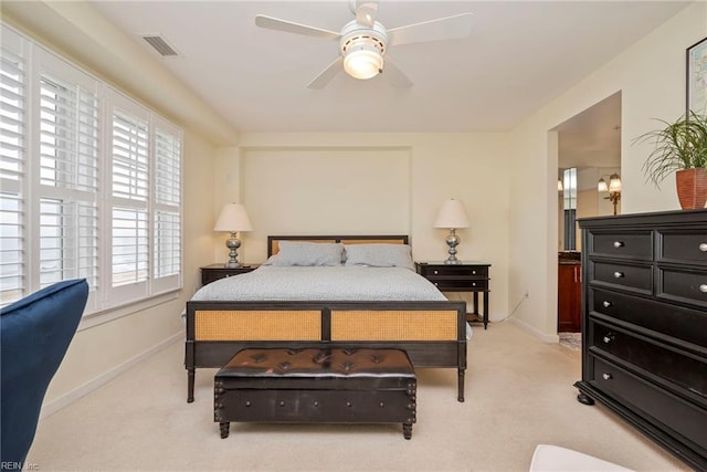 bedroom with a ceiling fan, light colored carpet, visible vents, and baseboards