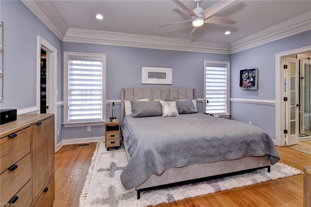 bedroom featuring crown molding, multiple windows, visible vents, and light wood-style floors