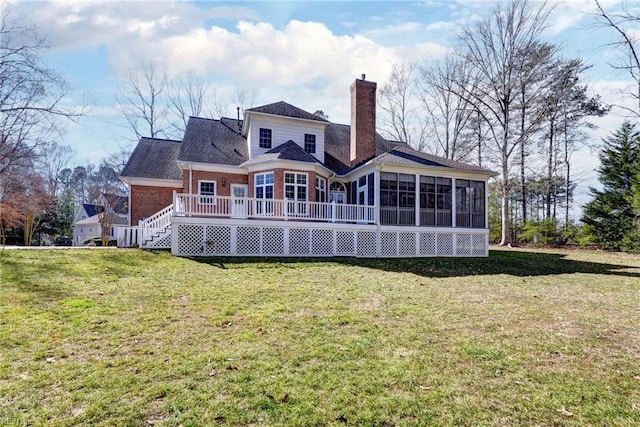 rear view of property featuring brick siding, a sunroom, stairs, a lawn, and a chimney