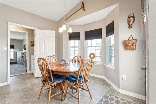 dining area featuring lofted ceiling and baseboards