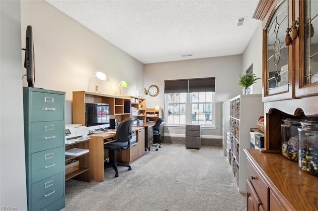 carpeted office with baseboards, visible vents, and a textured ceiling