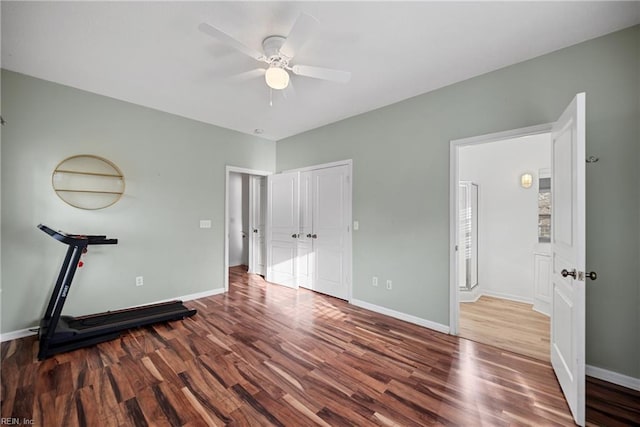 workout area with a ceiling fan, baseboards, and wood finished floors