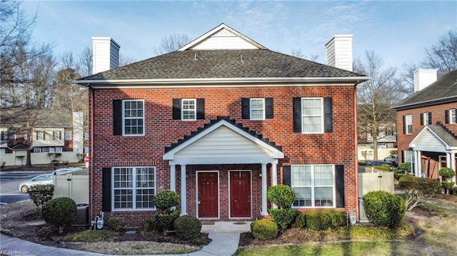 view of front of home featuring a chimney and brick siding