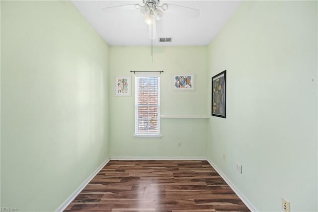 empty room with visible vents, ceiling fan, baseboards, and wood finished floors