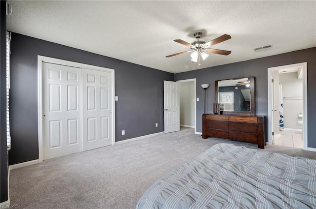 carpeted bedroom featuring a textured ceiling, ceiling fan, visible vents, baseboards, and a closet