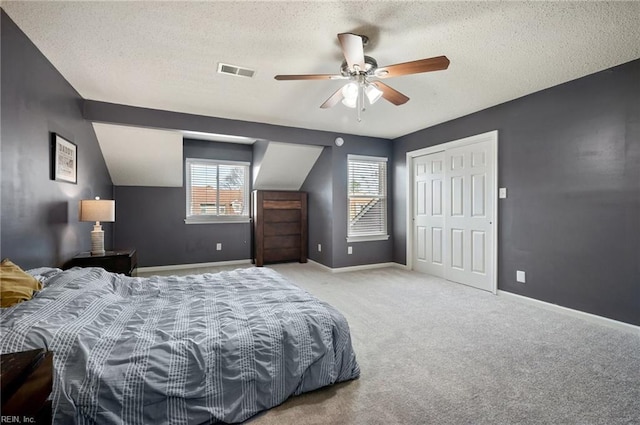 bedroom with carpet, visible vents, a textured ceiling, and baseboards