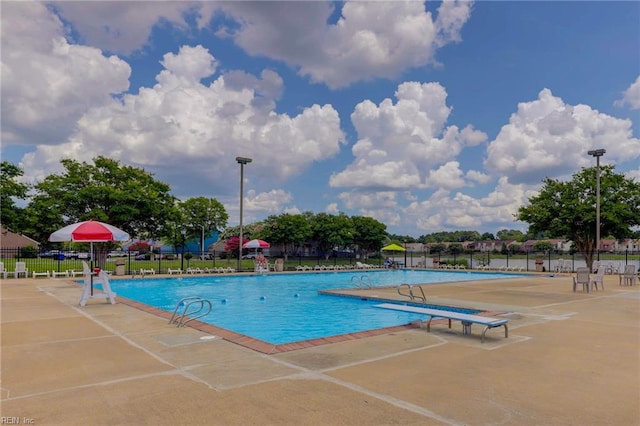 community pool featuring a patio and fence