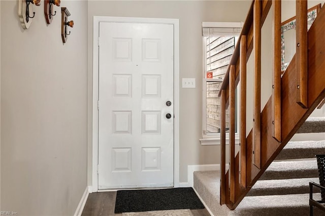 doorway with dark wood-style flooring and baseboards