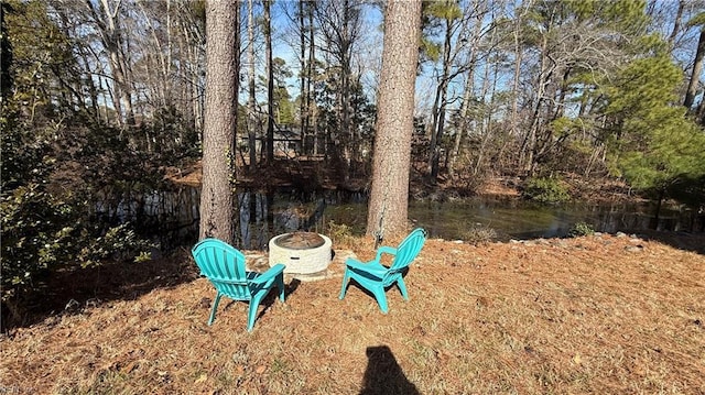 view of yard featuring a water view and an outdoor fire pit