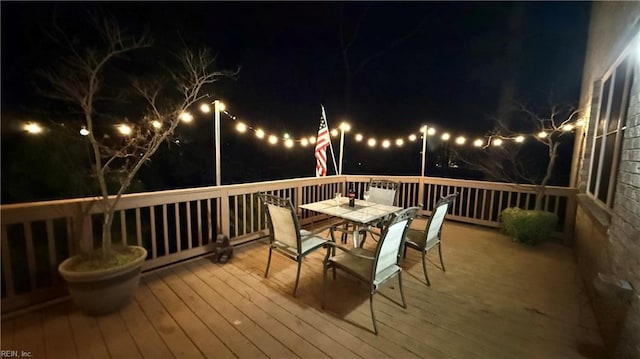 deck at night with outdoor dining area