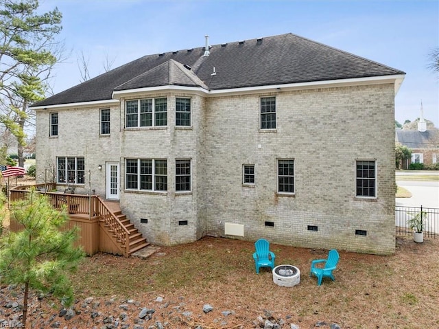 rear view of house featuring an outdoor fire pit, roof with shingles, crawl space, stairs, and brick siding