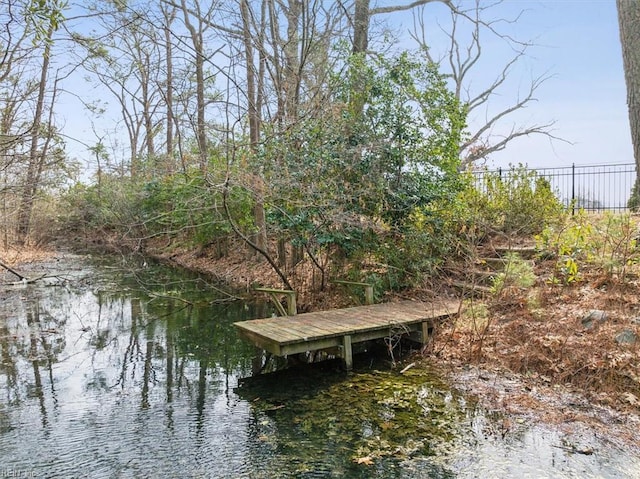 dock area featuring a water view and fence