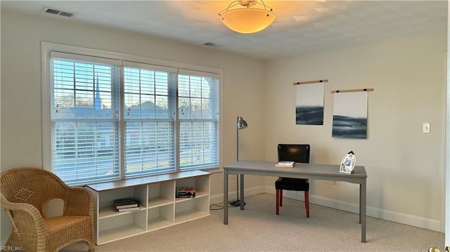 carpeted home office featuring visible vents and baseboards