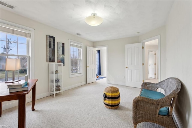 sitting room featuring a healthy amount of sunlight, carpet floors, baseboards, and visible vents