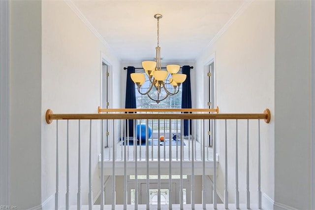 interior space with baseboards, ornamental molding, and an inviting chandelier