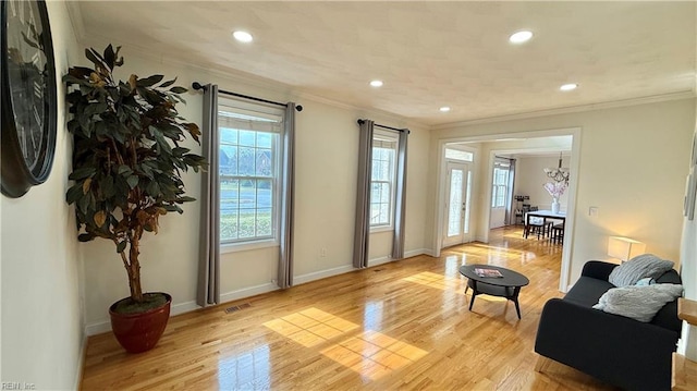 interior space featuring light wood-type flooring, baseboards, and crown molding