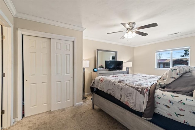 carpeted bedroom featuring visible vents, baseboards, a ceiling fan, ornamental molding, and a closet