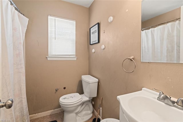 full bathroom with baseboards, a sink, and toilet