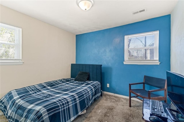 carpeted bedroom featuring visible vents and baseboards