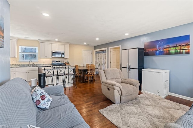 living room featuring baseboards, dark wood-type flooring, and recessed lighting