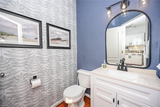 bathroom with wood finished floors, vanity, and toilet