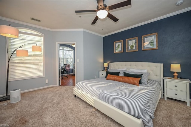 carpeted bedroom with ceiling fan, ornamental molding, visible vents, and baseboards