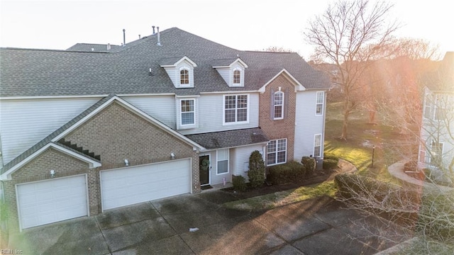 view of front of property with a shingled roof, concrete driveway, and an attached garage