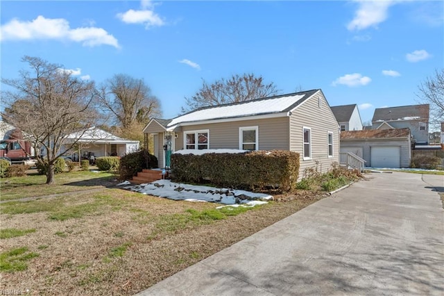 view of front of property with an outdoor structure, a detached garage, and a front yard