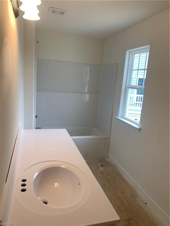 bathroom with visible vents, a sink, and baseboards