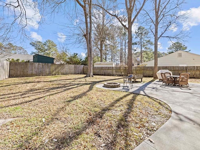 view of yard with a fenced backyard, a patio, and a fire pit