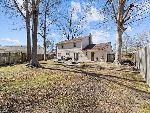 back of property with a patio area, a fenced backyard, a lawn, and a chimney