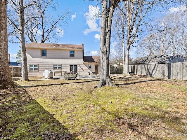 rear view of house featuring a patio area, a fenced backyard, and a yard