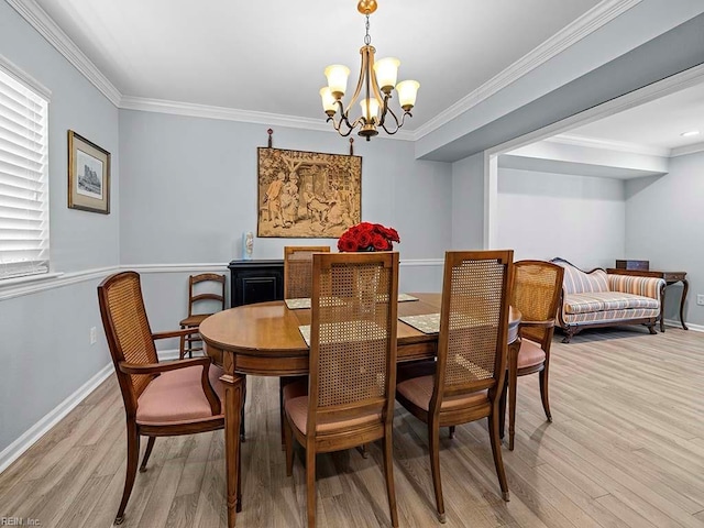 dining room featuring ornamental molding, light wood-type flooring, a chandelier, and baseboards