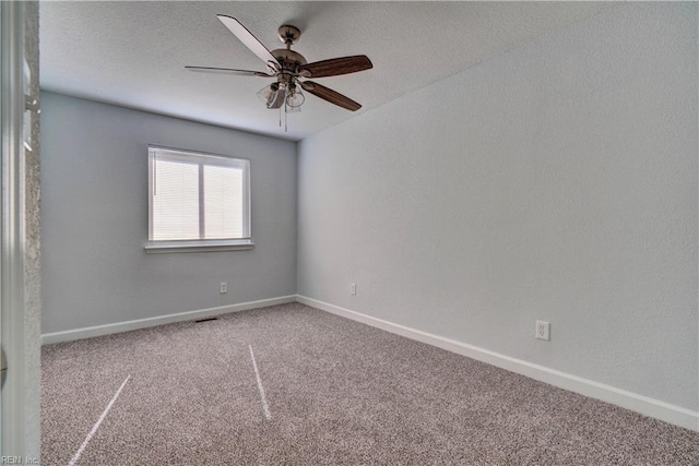 empty room with carpet floors, a textured ceiling, baseboards, and a ceiling fan