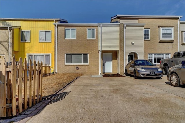 townhome / multi-family property with fence and brick siding