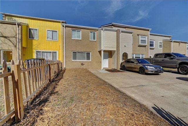 townhome / multi-family property featuring brick siding and fence