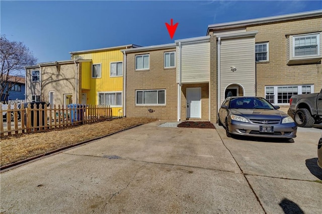 townhome / multi-family property featuring brick siding and fence