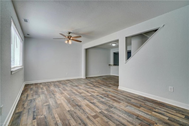 unfurnished room with ceiling fan, a textured ceiling, visible vents, and wood finished floors