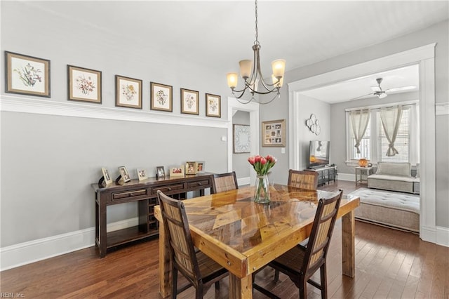 dining space with ceiling fan with notable chandelier, hardwood / wood-style floors, and baseboards