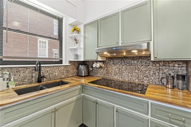 kitchen with butcher block countertops, under cabinet range hood, and green cabinets