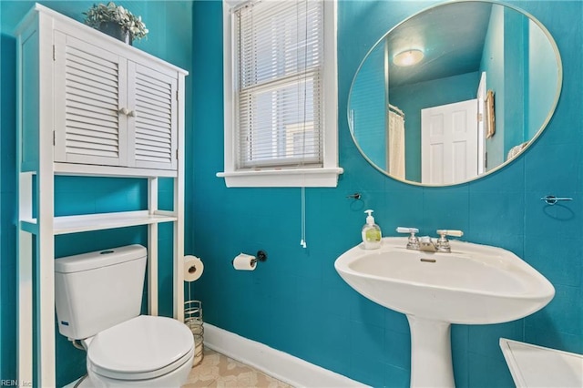 bathroom with baseboards, a sink, and toilet