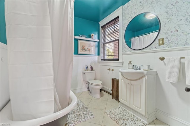 full bathroom featuring wallpapered walls, toilet, a wainscoted wall, tile patterned flooring, and a bath