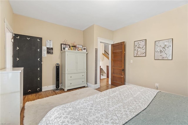 bedroom featuring baseboards and wood finished floors