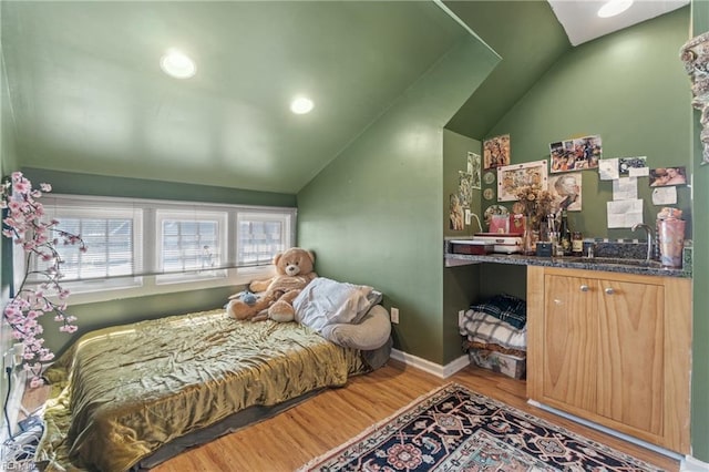 bedroom with recessed lighting, wood finished floors, a sink, baseboards, and vaulted ceiling