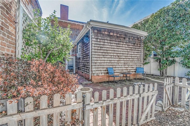 view of side of home with a fenced front yard and a chimney