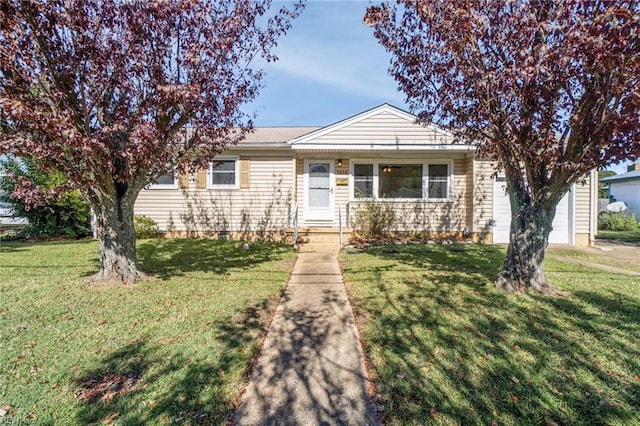 view of front of home with an attached garage and a front lawn