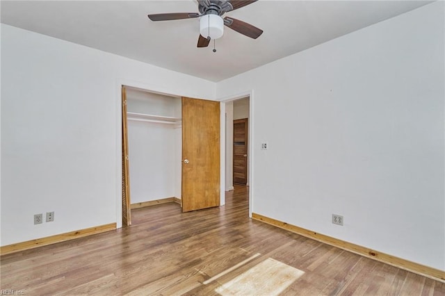 unfurnished bedroom featuring ceiling fan, a closet, baseboards, and wood finished floors