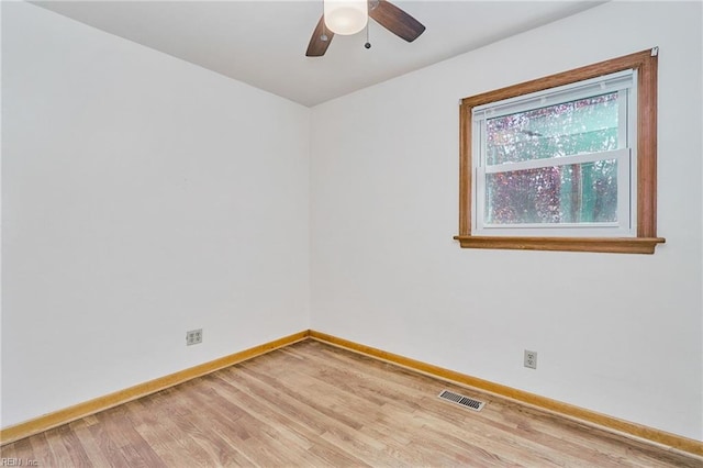 unfurnished room featuring a ceiling fan, wood finished floors, visible vents, and baseboards